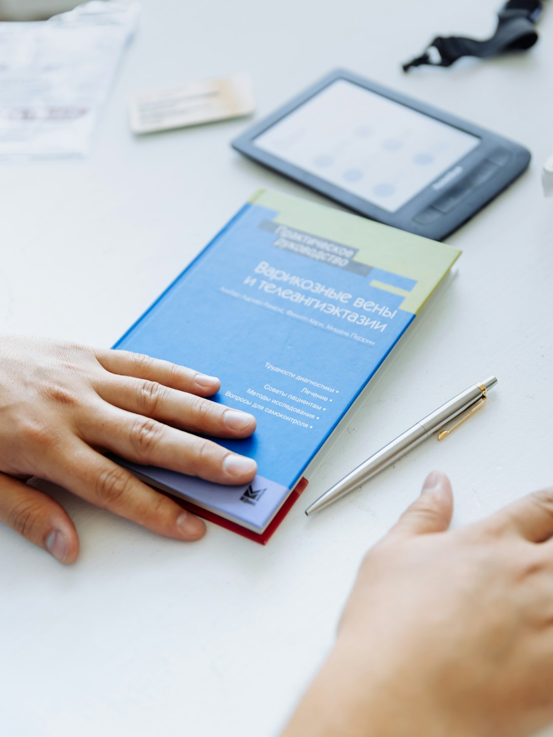 creative a-persons-hand-on-a-blue-folder-next-to-a-tablet-innu-y-voc