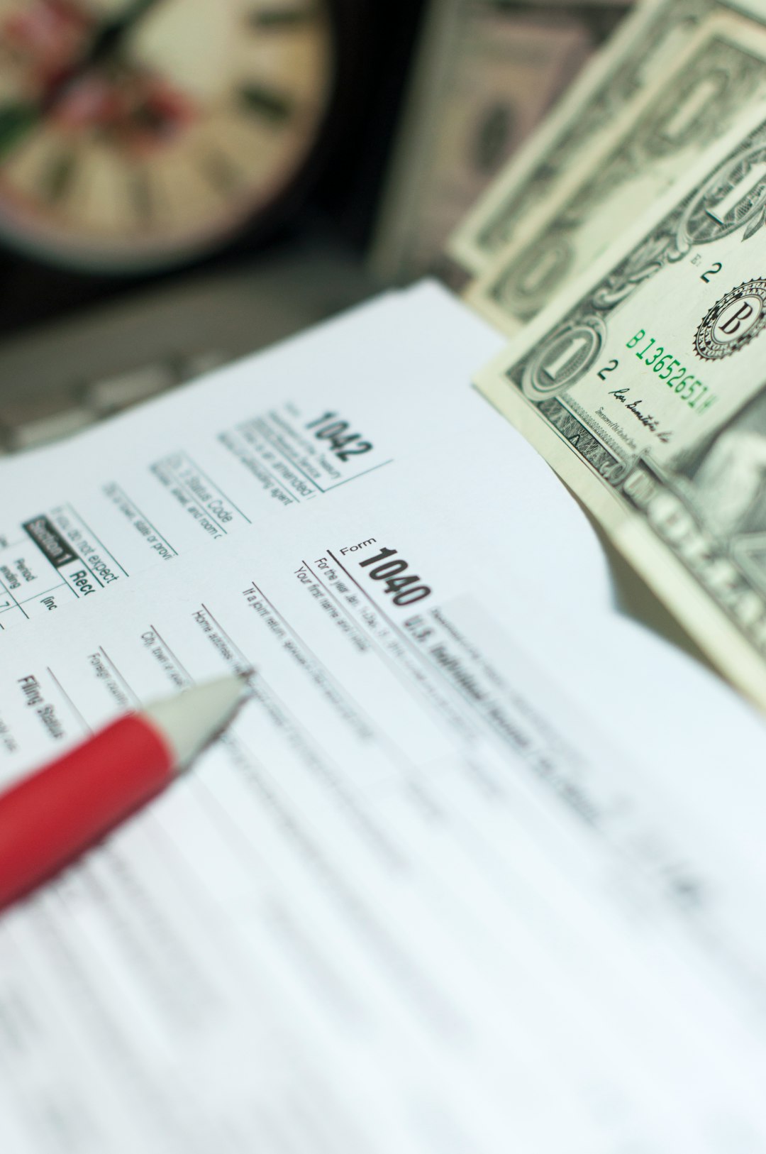 why-choose-us Tax Season: 1040 U.S. Individual Income Tax Return Form horizontal top view with an office laptop and blue calculator as background together with a red white pen preparation on taxation as foreground